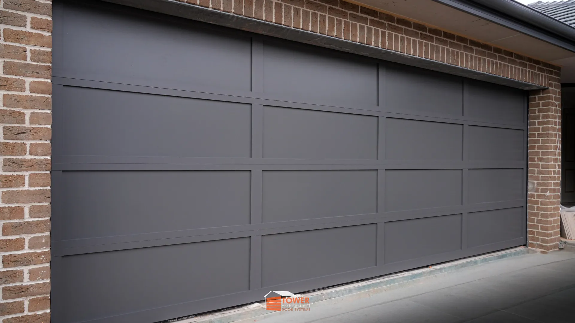 Architectural Range — Aluclad Series Location: Sydney Style Profile: A sleek, modern sectional door crafted from 2mm aluminium sheets, offering a smooth, uninterrupted façade ideal for contemporary architecture.