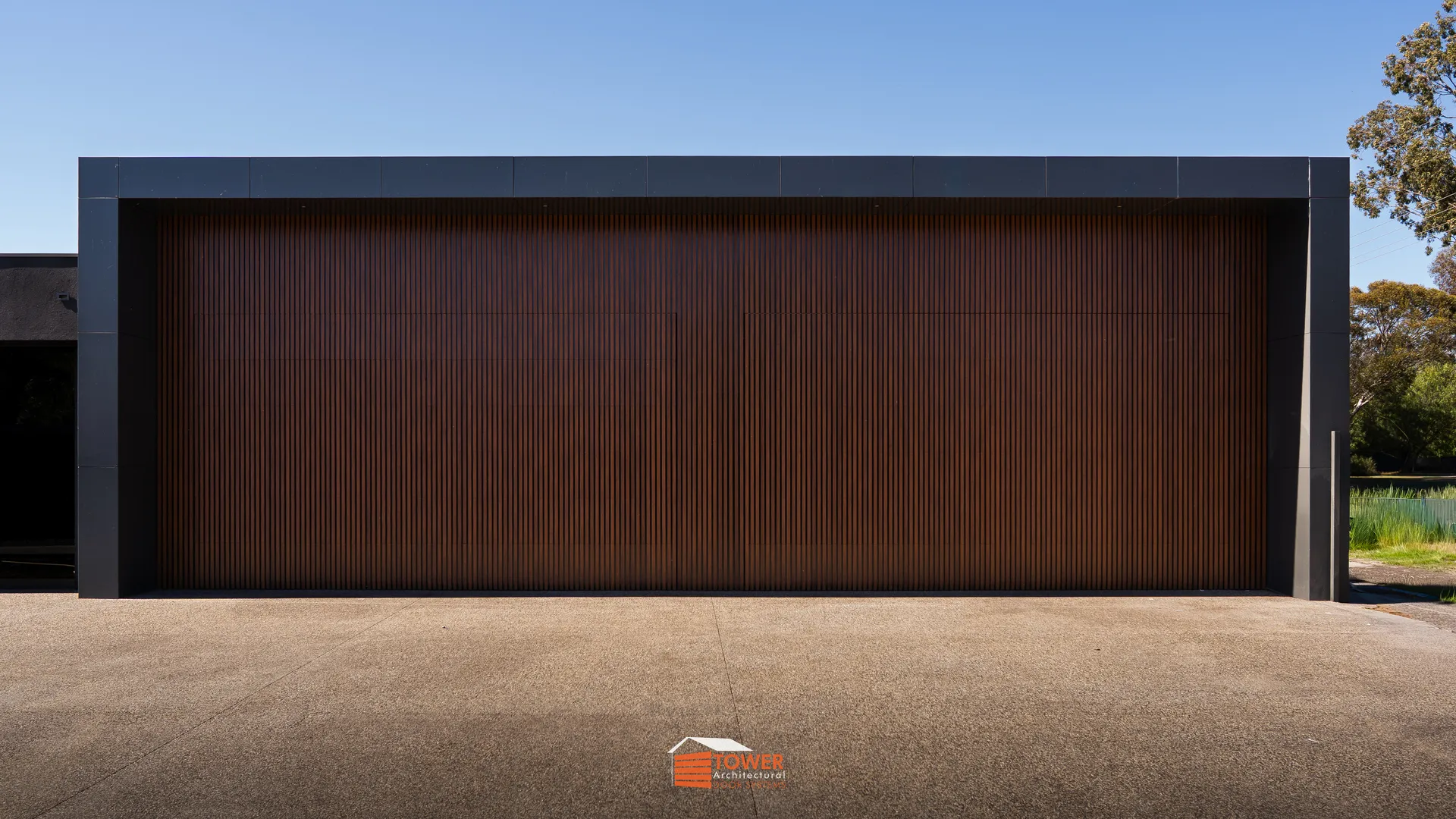 Architectural Range — Batten Series Location: Echuca, Rural Melbourne Style Profile: A commanding architectural statement defined by two expansive Flushmount Pro doors clad in 40×20 aluminium wood-look battens.