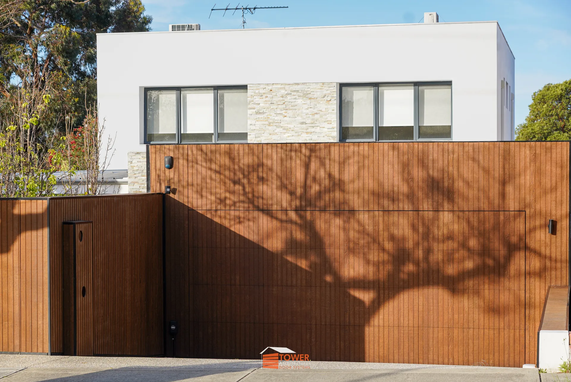 Architectural Range — Natural Series Location: Perth Style Profile: A statement in refined contemporary design, this Flushmount Pro installation features a seamless shiplap timber façade that wraps the garage door and boundary wall as one continuous plane.