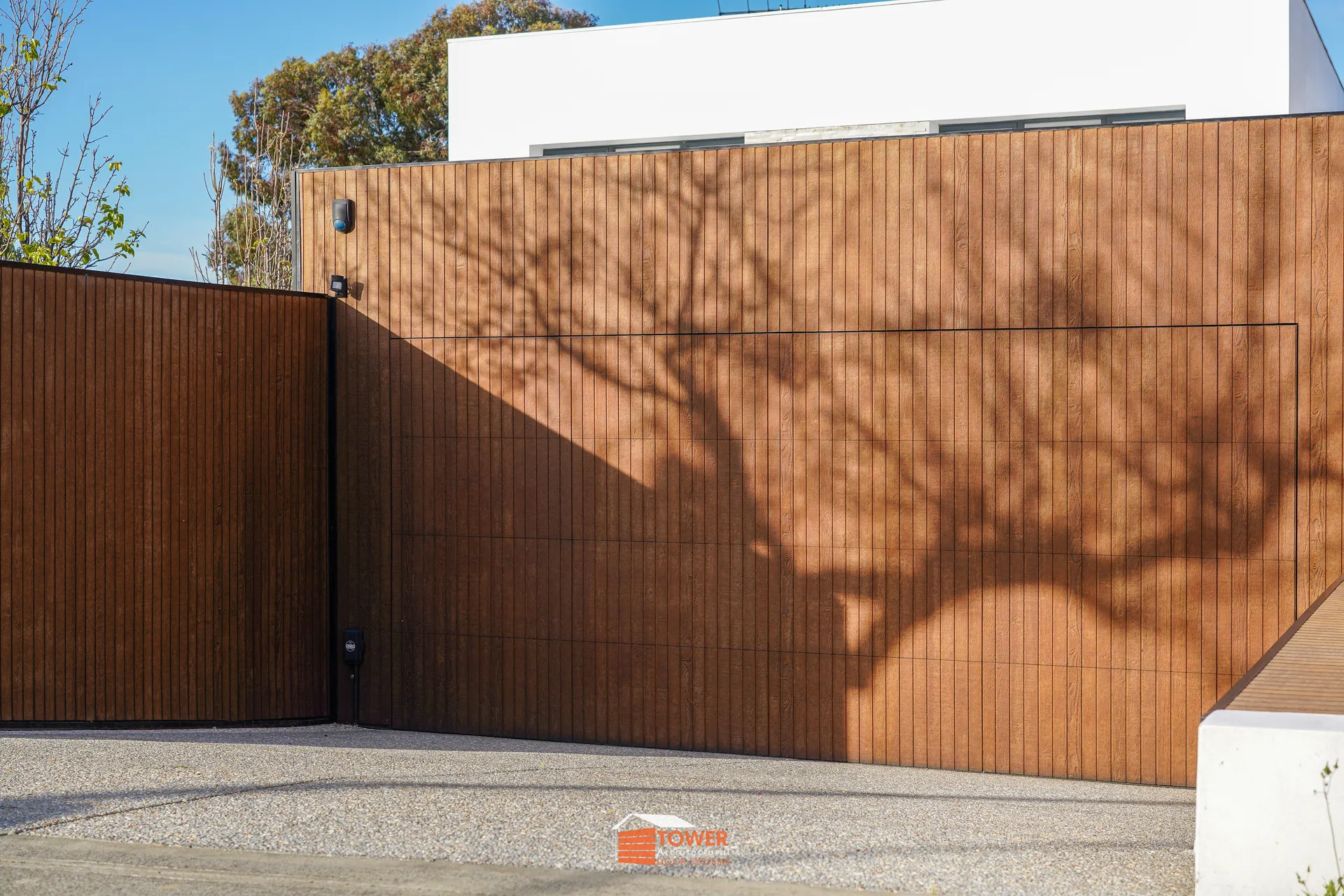 Architectural Range — Natural Series Location: Perth Style Profile: A statement in refined contemporary design, this Flushmount Pro installation features a seamless shiplap timber façade that wraps the garage door and boundary wall as one continuous plane.