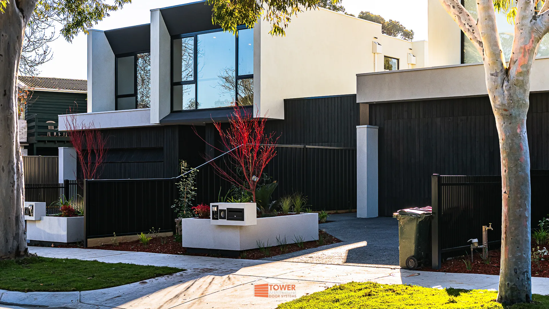 Architectural Range — Natural Series Location: Melbourne Builder: Amazing Homes Style Profile: This contemporary residence showcases a Flushmount Pro garage door clad in vertically-run natural timber shiplap, stained in a deep charcoal tone.